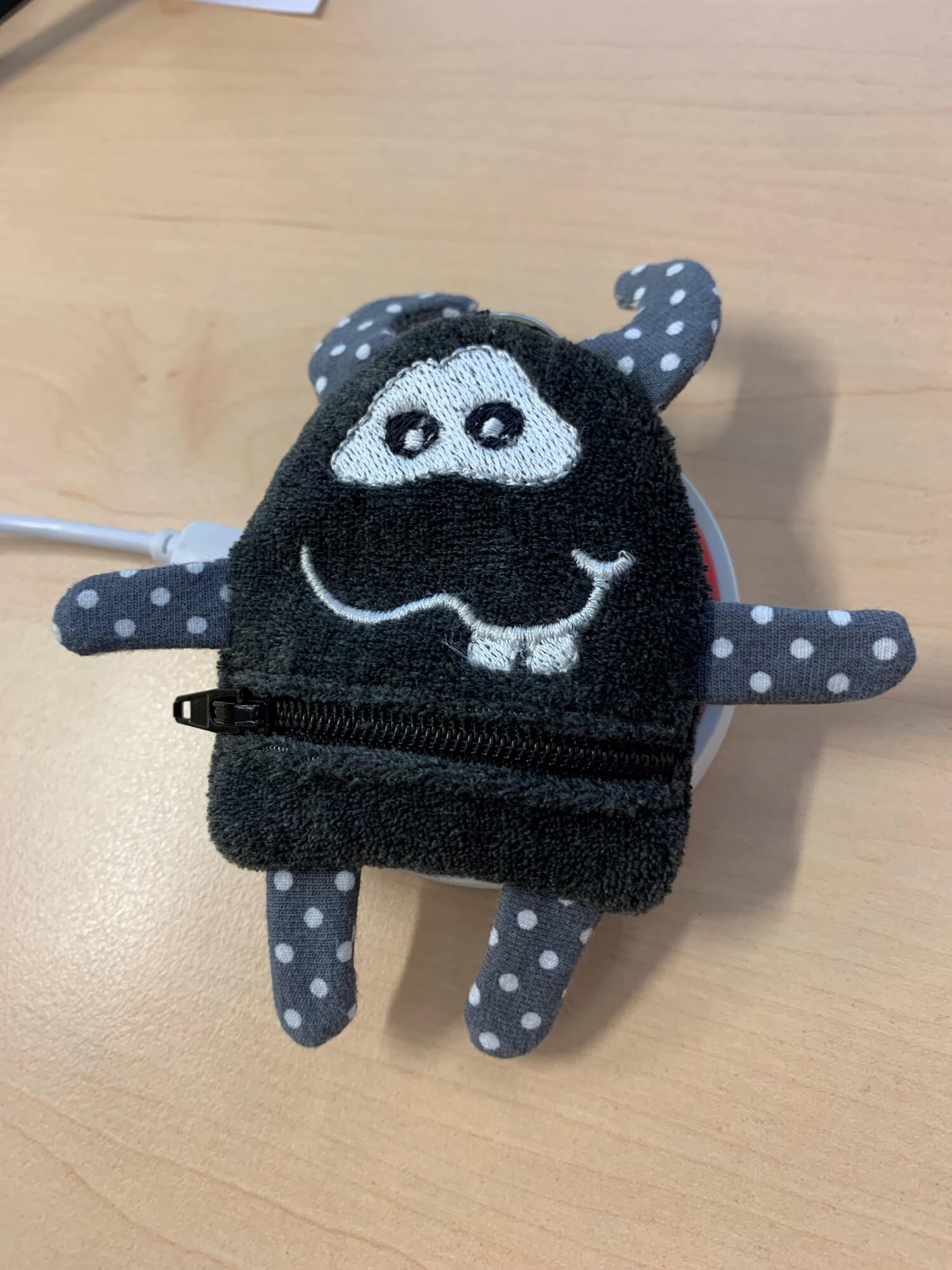 Monster_grau_auf_Ladepad Der Otiom-Tag kann in der Tasche geladen werden