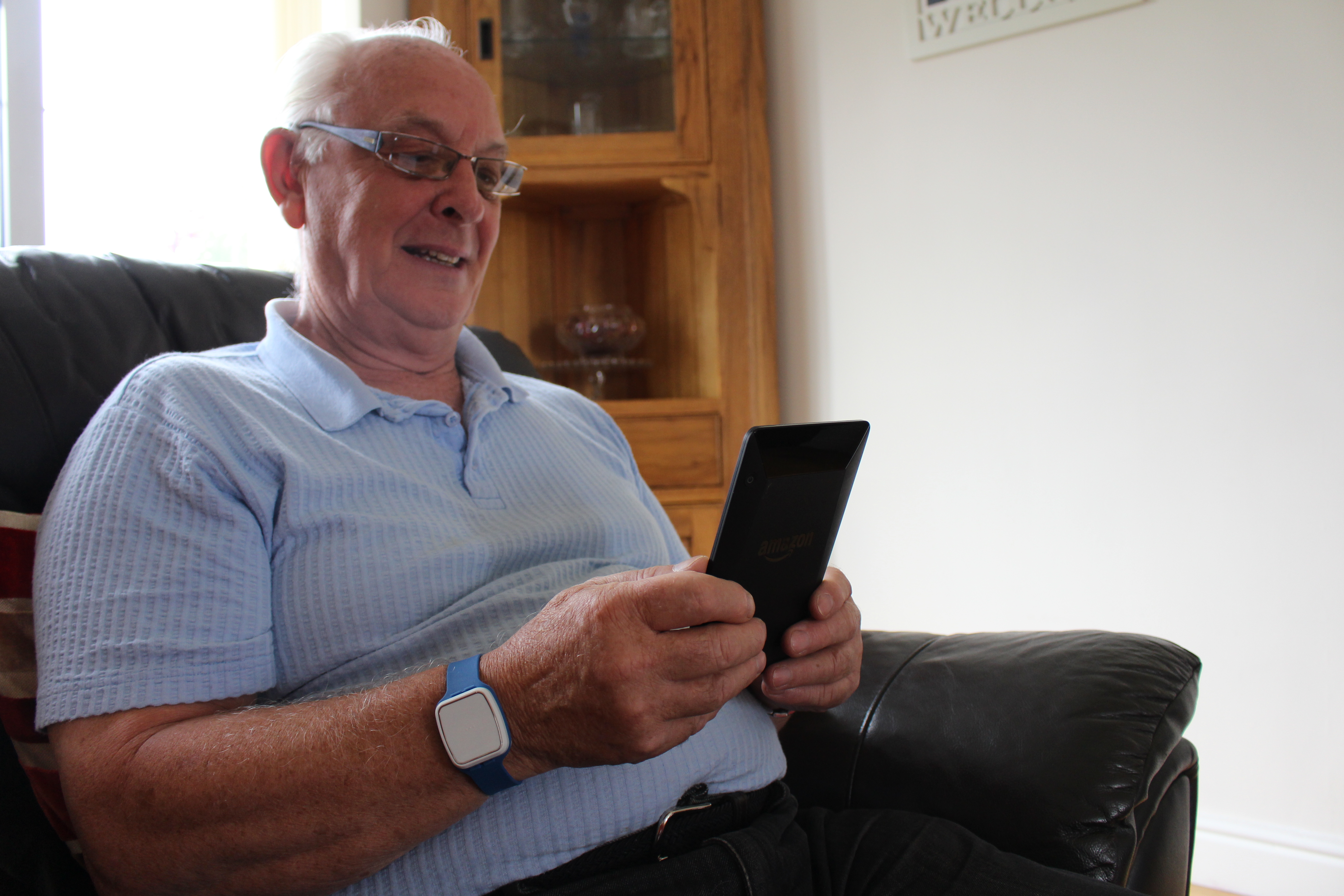 Man-wearing-Vibby-on-wrist-looking-at-Kindle